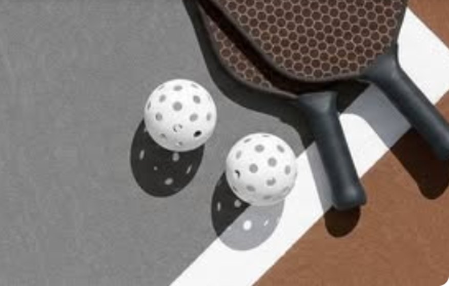 Pickleball paddles and perforated balls on a court